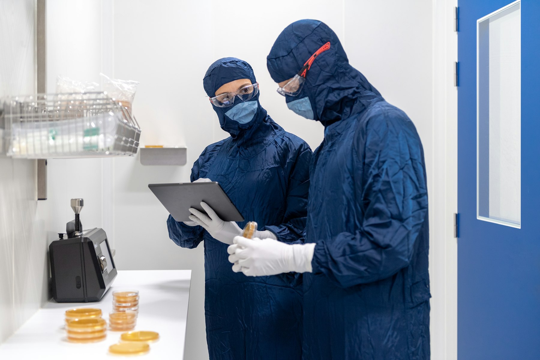 Technicians in protective suits working in a cleanroom