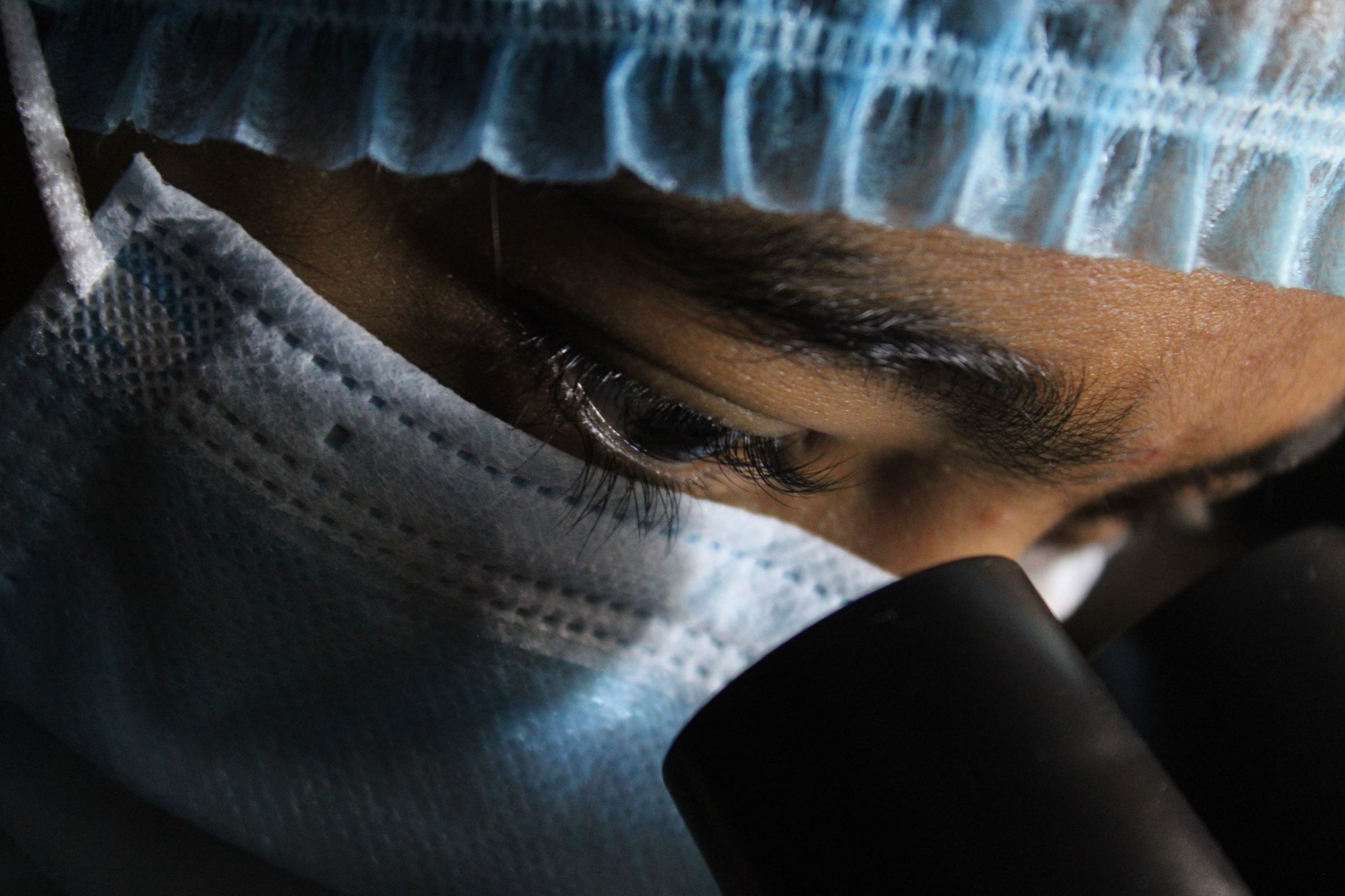 Scientist examining a sample through a microscope